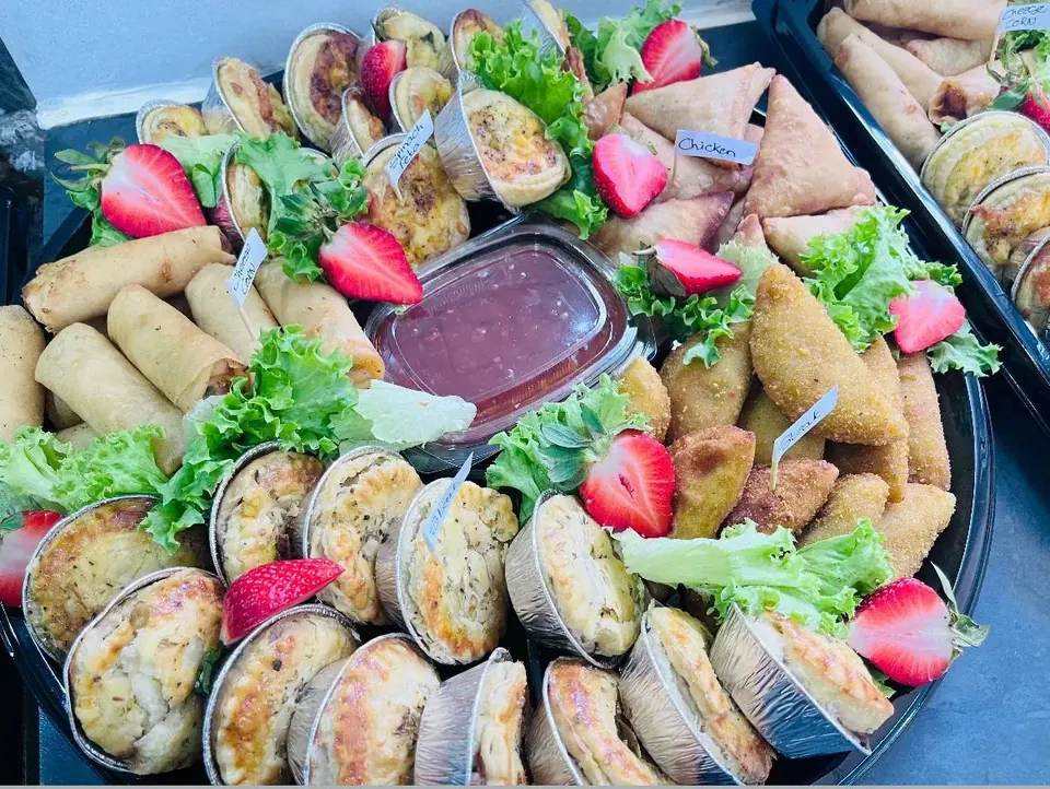 Savoury platter of samoosas, spring rolls, pies and quiches with strawberries and a dipping sauce